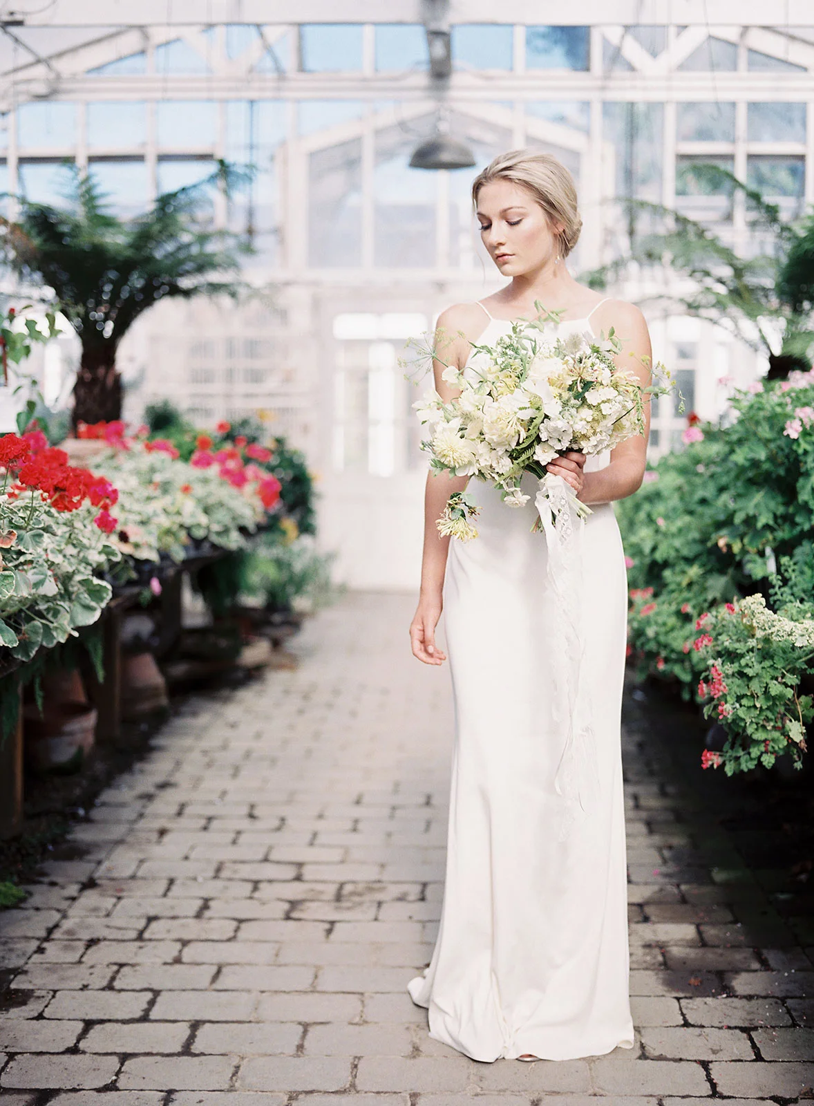 bride walking down greenhouse aisles